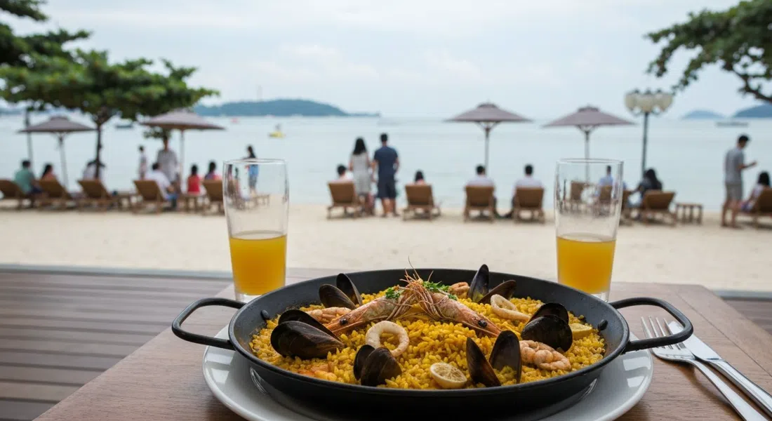 una paella para compartir en FOC By The Beach en la playa de Palawan, arroz con azafrán y mariscos servidos junto a la playa con el mar al fondo